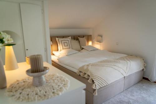 BleckhausenEifel21 - stilvolles Haus in der Vulkaneifel的白色卧室配有床和桌子