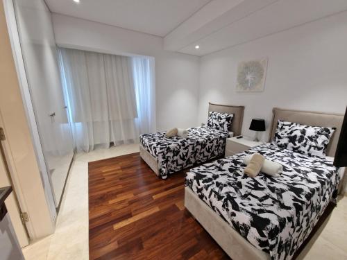 PaphosLuxury 6 bedrooms villa in Cyprus的铺有木地板的客房内的两张床