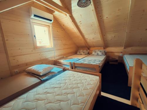 萨拉热窝Guest house Nizama's Place的小木屋内设有一间带三张床的卧室