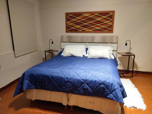 耶尔瓦布埃纳Azules de Abril的一间卧室配有一张带蓝色棉被的床
