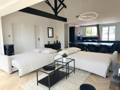 拉罗谢尔Les appartements du Carnot - Terrasses et Jardins的客厅配有两张床和一张桌子