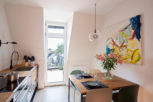 鲁尔河畔米尔海姆Renoviertes Design Apartment mit Toller Terasse的厨房配有一张桌子,上面放着花瓶