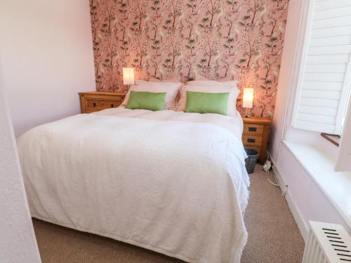 赫尔斯顿Pentira的卧室配有白色床和花卉壁纸