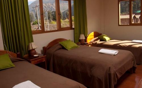 乌鲁班巴波萨达特莱斯玛丽亚酒店的客房设有两张带绿色窗帘和窗户的床。