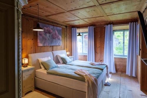 豪尔兹高Facetten Reich 32的卧室配有一张床铺,位于带木墙的房间内