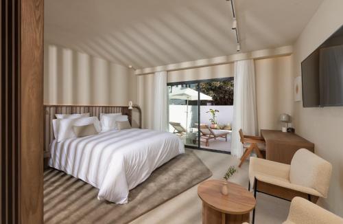 马贝拉Anfitrión Villas & Suites的一间卧室设有一张床和一间客厅。