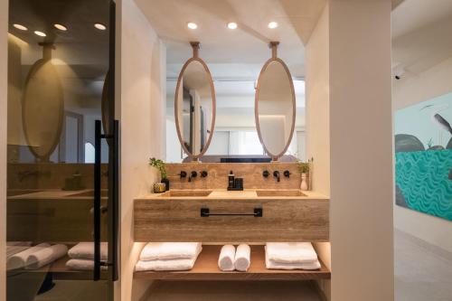 马贝拉Anfitrión Villas & Suites的一间带水槽和两面镜子的浴室