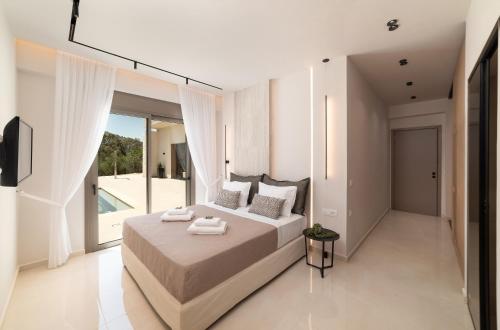 MouríonVilla El by PosarelliVillas的一间卧室设有一张大床和一个大窗户