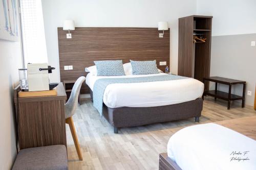 博韦大教堂酒店的一间卧室设有两张床和木制床头板