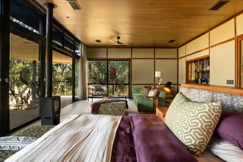 提姆巴瓦提禁猎区Tanda Tula Safari Camp的一间卧室设有一张床和一间客厅。