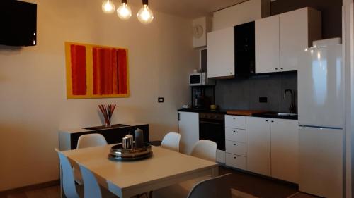 Castellino TanaroPeter Pan的厨房配有白色橱柜和桌椅