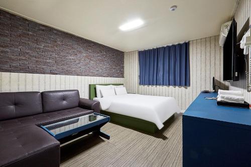 水原市Galleria Hotel的酒店客房,配有床和沙发