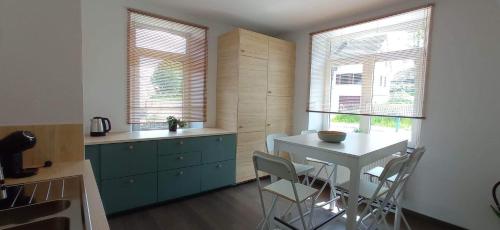 雅莱L'appartement du CPW的厨房配有桌椅和2扇窗户。