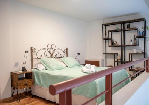 布宜诺斯艾利斯Ayres de Saavedra - Dot Baires Shopping的一间卧室配有一张带绿床单和枕头的床。