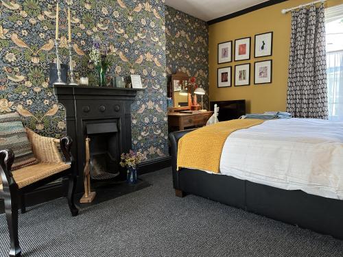 塔维斯托克One Drake Road, Tavistock, Devon的一间卧室配有一张床和一个壁炉