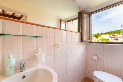 苏比亚诺La Finestra Sul Fiume的一间带水槽和卫生间的浴室以及窗户。