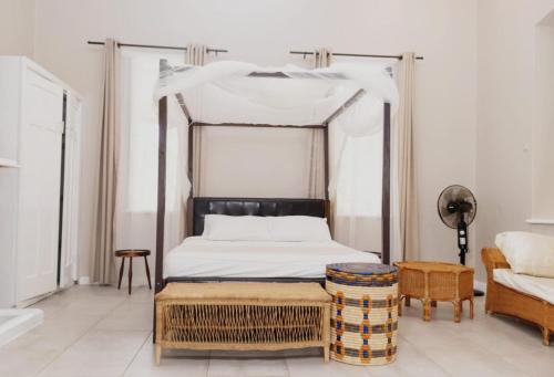 ZombaPaphiri House的一间卧室配有天蓬床和沙发