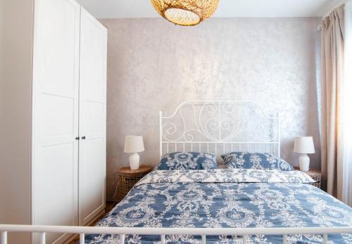 锡尼Apartman Karla的卧室配有蓝色和白色的床和吊灯。