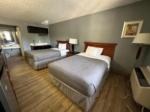 圣安东尼奥HillView Inn at Six Flags Fiesta的酒店客房配有两张床和一张书桌