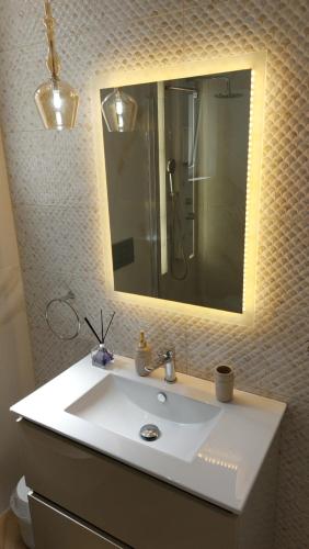 波塔莫斯Semiramis Apartment的浴室设有白色水槽和镜子