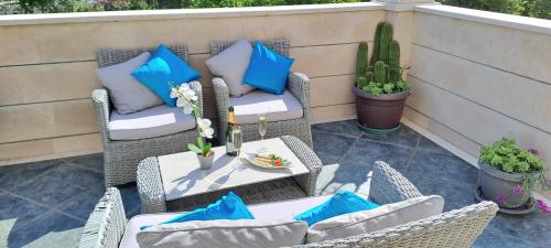 默克斯卡Villa Dubelj Dubrovnik的庭院设有藤椅和桌子,并提供蓝色枕头。