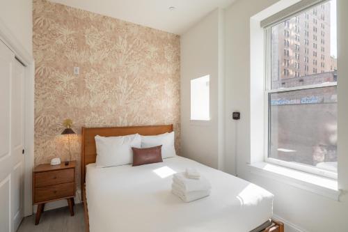 费城Sosuite at French Quarters - Rittenhouse Square的卧室配有白色的床和窗户。