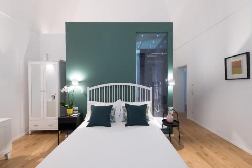 特拉尼I Colori della Puglia Rooms的卧室配有白色的床和蓝色的墙壁