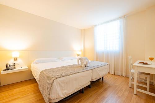 萨科马Hotel Rosella affiliated by Intelier的一间卧室设有一张大床和一个窗户。