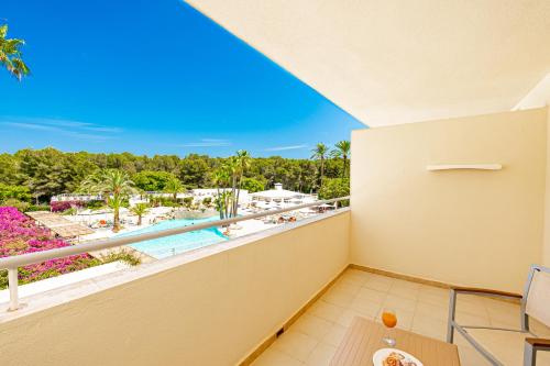 萨科马Hotel Rosella affiliated by Intelier的享有游泳池和棕榈树景致的阳台