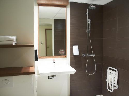 第戎第戎克莱蒙梭钟楼会议酒店的浴室配有盥洗盆和带镜子的淋浴