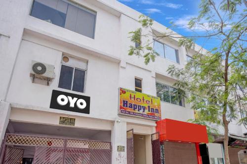 巴特那Super OYO Hotel Happy Inn的白色的建筑,上面有酒店幸福的旅馆标志