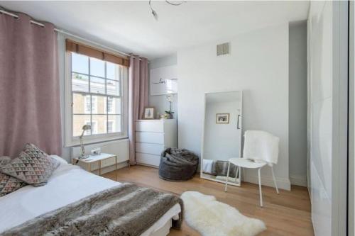 伦敦Stylish 2 FLOOR 2BED house 1 MIN walk to Camden station! FREE PARKING!的卧室配有白色的床和窗户。