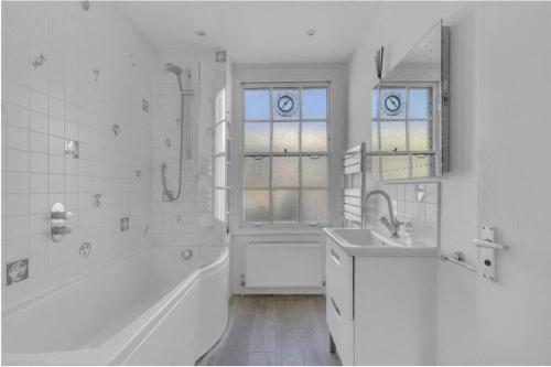 伦敦Stylish 2 FLOOR 2BED house 1 MIN walk to Camden station! FREE PARKING!的白色的浴室设有浴缸和水槽。