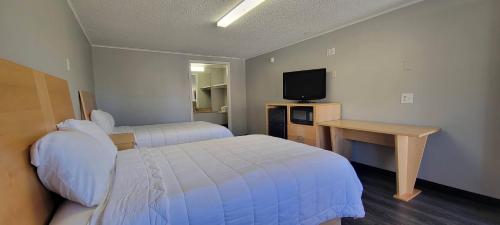 纽卡斯尔Superlodge的酒店客房设有两张床和电视。