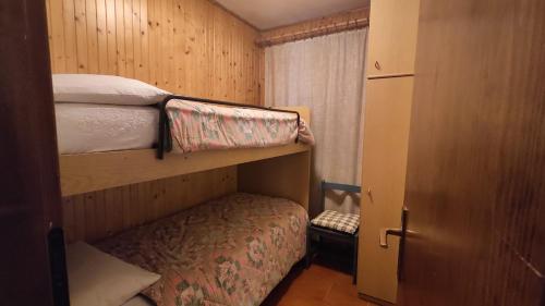 罗卡皮耶托雷Residence Marmolada的一间小卧室,配有两张双层床和一个衣柜