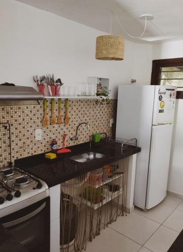 皮帕Casa com vista mar的厨房配有白色冰箱和黑色台面
