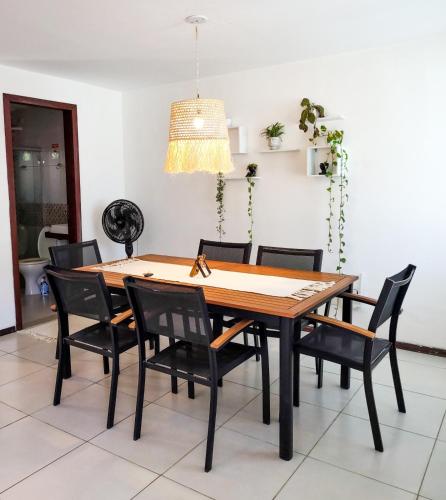 皮帕Casa com vista mar的餐桌、黑色椅子和灯具