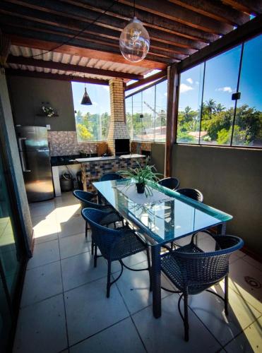 皮帕Casa com vista mar的一间设有玻璃桌和椅子的用餐室