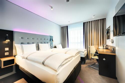 威斯巴登Premier Inn Wiesbaden City Centre的酒店客房设有一张大床和一张书桌。