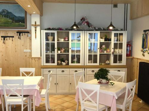 泽高杰耶泽尔斯科Penzion Valerija的厨房配有白色橱柜和白色的桌椅