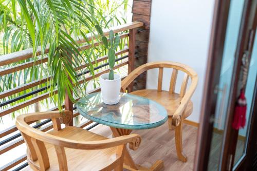 Ban Khok LoMadee Spa & Resort的种植了植物的阳台,配有一张桌子和两把椅子