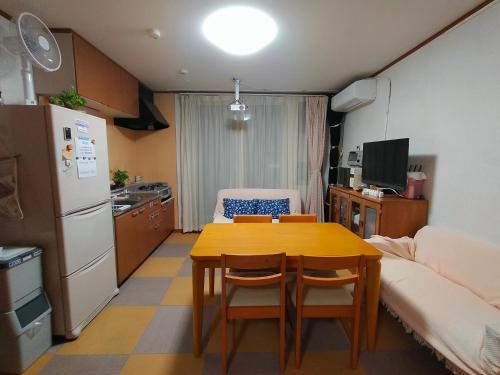 札幌At Home N23的一间带桌子的小厨房和一间带沙发的厨房