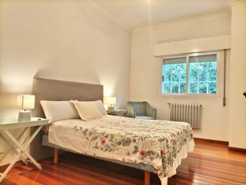 拉科鲁尼亚Oasis en Ponte San Lázaro的一间卧室配有一张床、一张书桌和一个窗户。