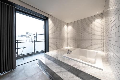 全州市Jeonju Jazz Around Hotel的带浴缸的浴室和大窗户
