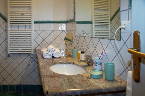 伊斯基亚Hotel Sunset Green的浴室的柜台设有水槽和镜子