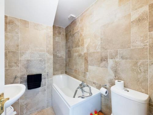 沃特福德Holiday Apartment Iris的带浴缸、卫生间和盥洗盆的浴室