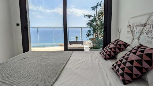 贝尼多姆SUNSET WAVES sea view apartments的一间卧室设有一张床,享有海景