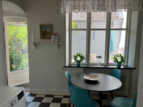 斯塔德Villa Brigitta, havsnära boende mittemot Klostret i Ystad centrum的厨房配有桌椅和窗户。