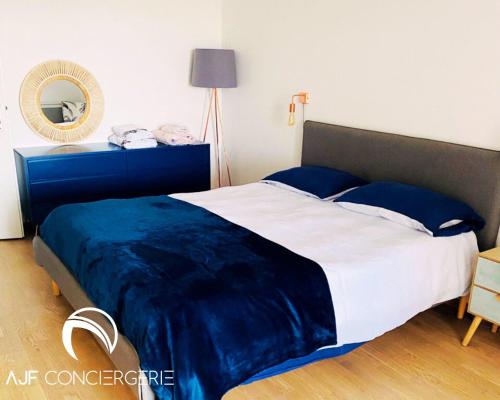 阿雅克修Appart'hotel grande terrasse vue mer的一间卧室配有一张带蓝色毯子的大床