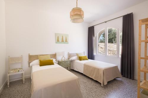 塔拉桑纳阿拉贡Torre Chiguita的白色客房的两张床,设有窗户